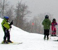 Kids on skis at the top of a hill