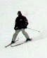 Person with skis in a V slowly going down a hill
