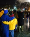 Families standing on the ice holding each other watching the fireworks