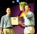 Twins, one holding a head of lettuce, the other the box with the stuff to be shown