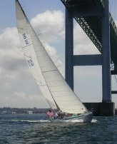 Sailboat under a big bridge leaning over