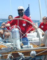 Me in sunglasses and hat holding big wheel steering a boat