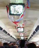Plane ceiling with TVs and blue and red crepe paper