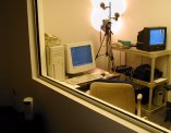 Looking through a window into a room with a PC, video camera, etc.