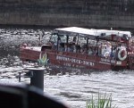 Red vehicle with white awning in the river