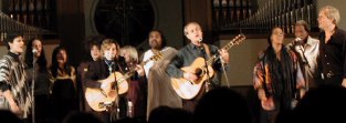 Lots of folk singers, some with guitars, on stage singing