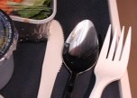 Airline food tray with plastic knife and fork, metal spoon