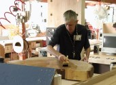 Worker varnishing huge slice of a tree trunk