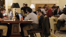 Students at tables and in chairs with laptops