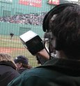 Woman wearing headphones holding radar gun up with field visible