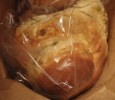 Round bread in plastic bag in paper bag