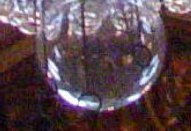 Glass sphere at the bottom with wires hanging down ending in rings