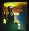 Chris in trenchcoat and hat looking at similar person painted in silhouette