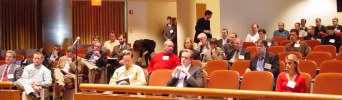 Dozens of people in a theater arrangement at a nice conference center