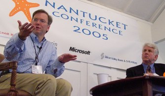 Eric and Bob on a low podium sitting in chairs with a Nantucket Conference banner behind
