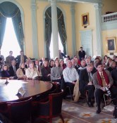 Dozens and dozens of people sitting with draped windows behind